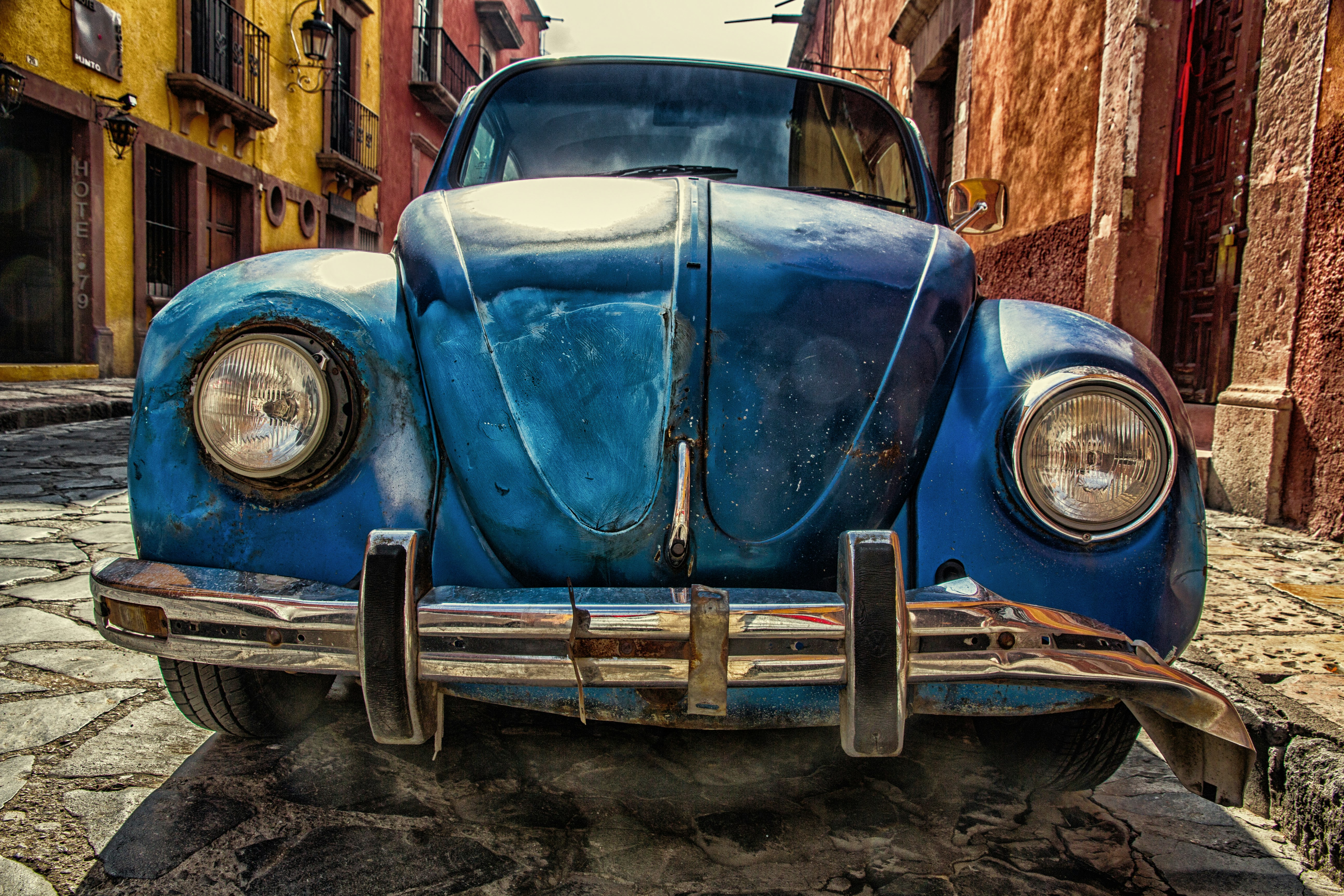 blue vehicle parked near building at daytime